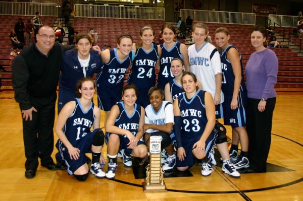The Saint Mary-of-the-Woods College basketball team poses with the Clabber Girl Trophy