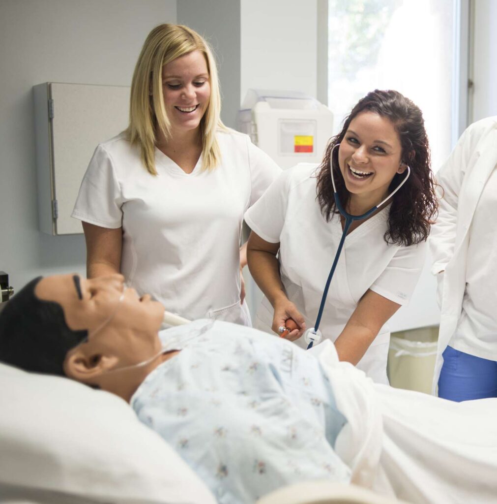 Nursing students working with a fake patient