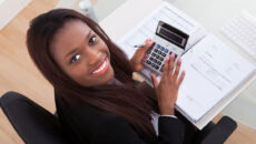 Woman using calculator at desk