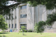 A view of Rooney Library surrounded by pine trees