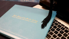 Diploma and tassel sitting on laptop