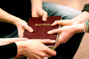 group of students holding a bible