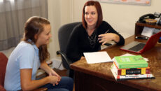 Student meeting with teacher in office