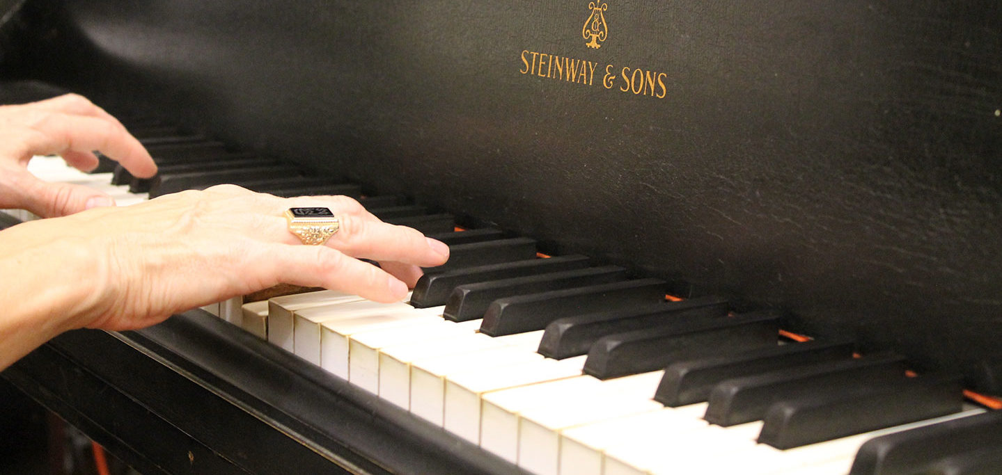 hands on piano with the woods ring