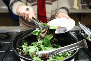 Someone getting a salad at the dining hall