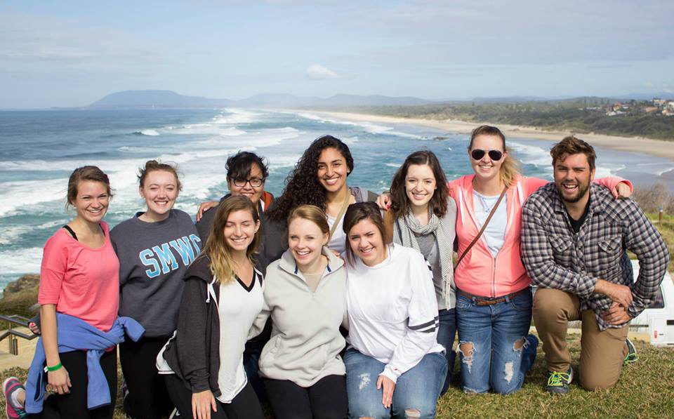 Students posing in front of the ocean
