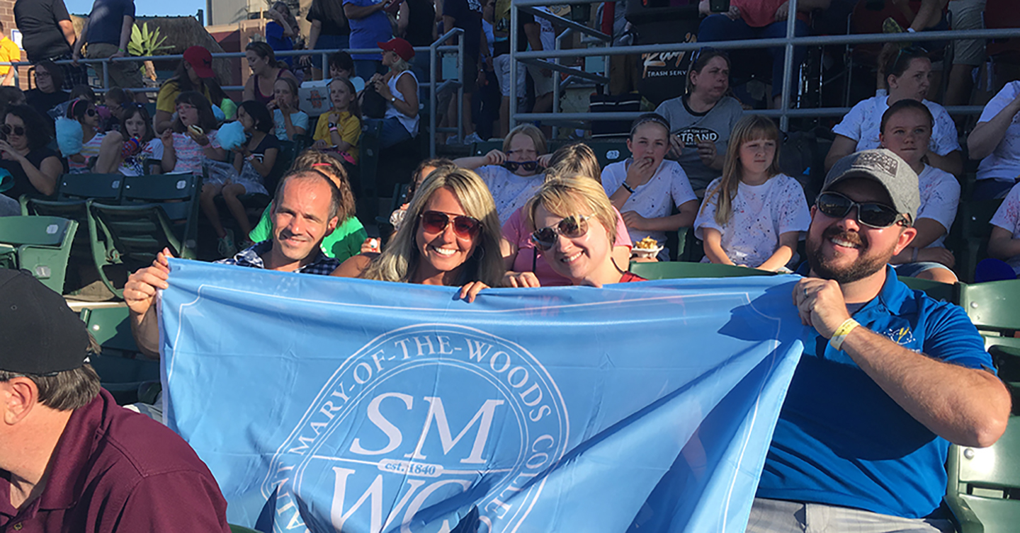 Alums holding a SMWC flag