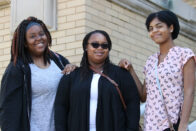 Three students standing outside of Le Fer