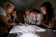 Nursing students looking at a skeleton on a screen