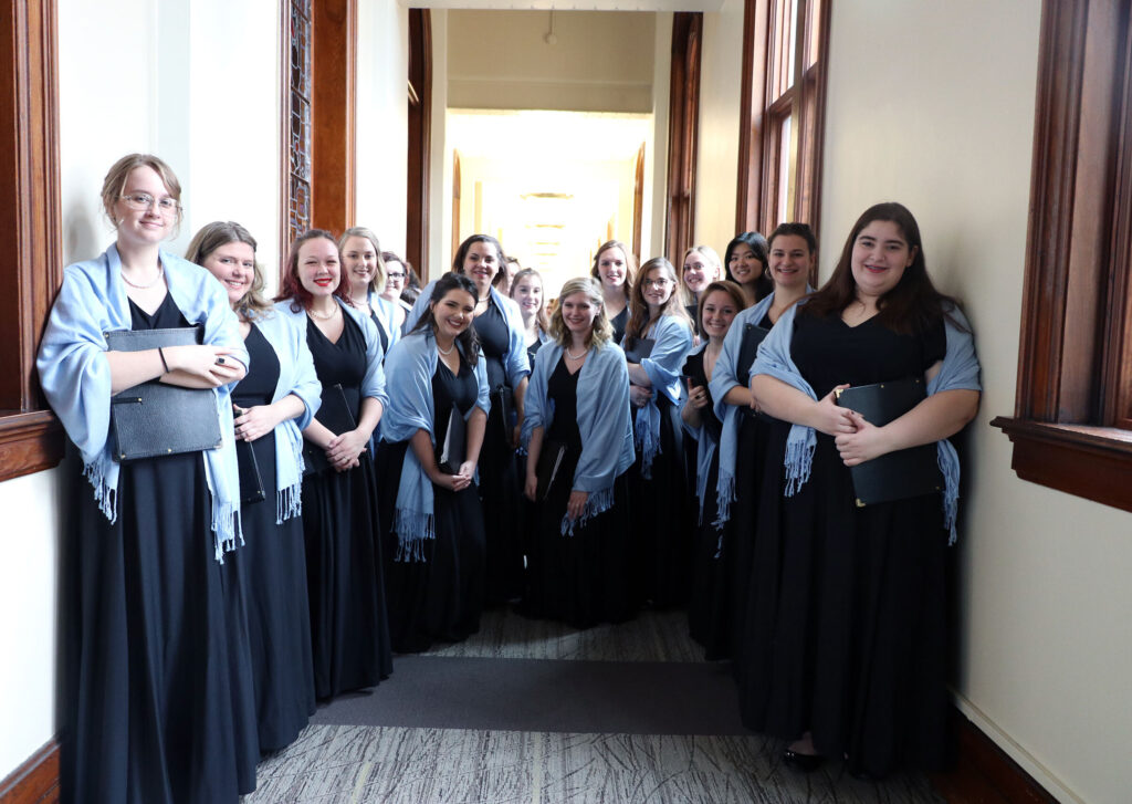 Choir students smile for a group picture before a concert