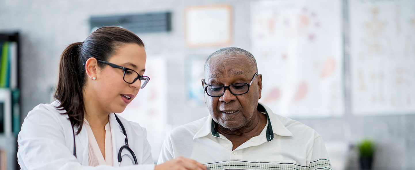 Nurse showing elderly man information on tablet