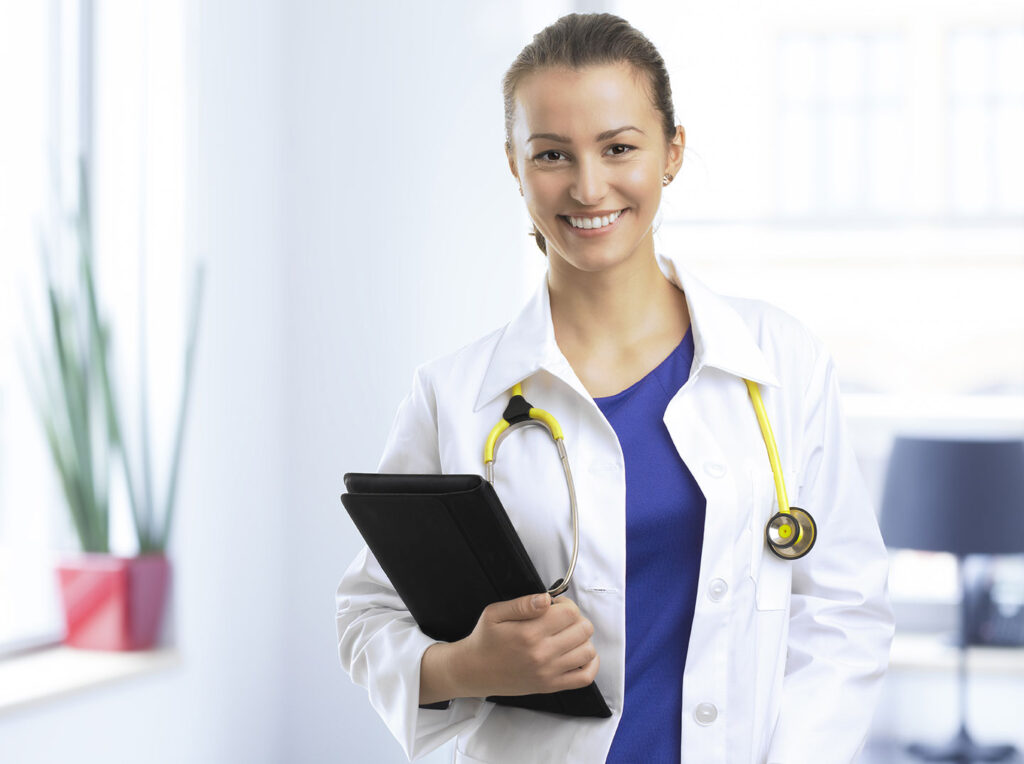 Nurse standing smiling in hospital setting