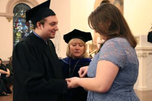 Beth Yoder placing Woods Ring on the hand of Joel Yoder at the ceremony