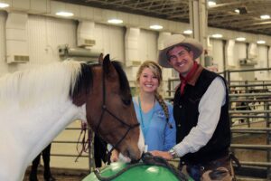 McKayla Tichenor and Jesse R. Peters standing with a horse in a staff