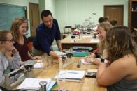 Tsarasi showing group of students measurement on scale in a classroom