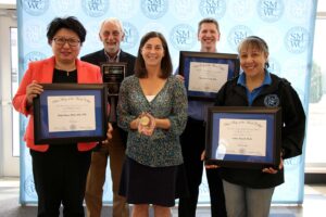 The award winners standing in the Knoerle Center atrium holding their awards.