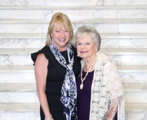 President King standing with Frances Kramer in front of the Le Fer entryway staircase