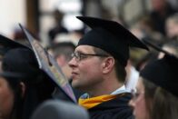 Graduates sit watching the commencement ceremony