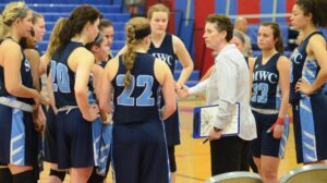 Coach Bradley talking with students during a basketball game.