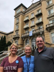 Lambermont stands with her parents in front of Le Fer Hall