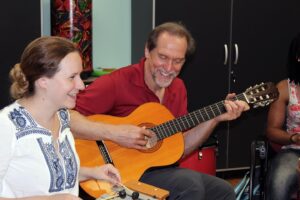 Alan Turry playing guitar with a group of graduate students