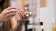 Closeup of student holding chemistry model in a lab