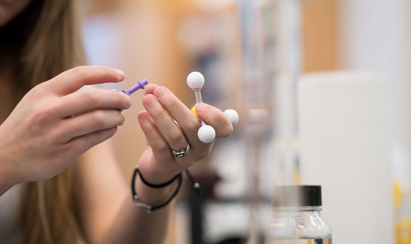 Closeup of student holding chemistry model in a lab