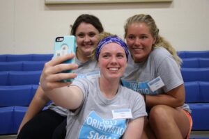 Awbrey, Taylor, and Shuler take a selfie in the gym during orientation