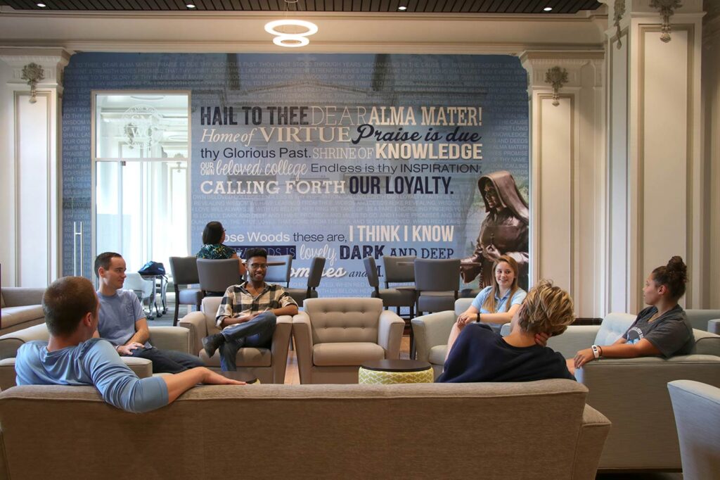Students sitting in the middle of Sullivan Parlor smile and talk.