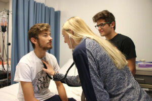 Loebker and Turner testing stethoscope on Nuest during class exercise.