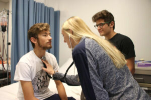 Loebker and Turner testing stethoscope on Nuest during class exercise.