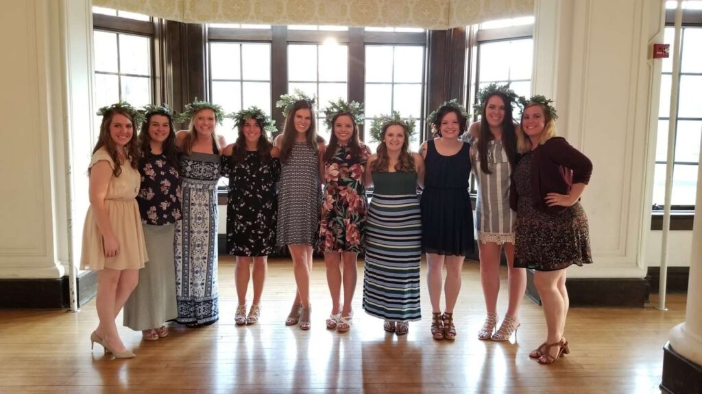 Group of students wearing their oakleaf crowns pose for a picture in the ballroom