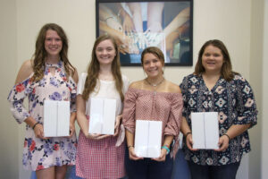 The SMTG scholarship recipients holding their tablets.