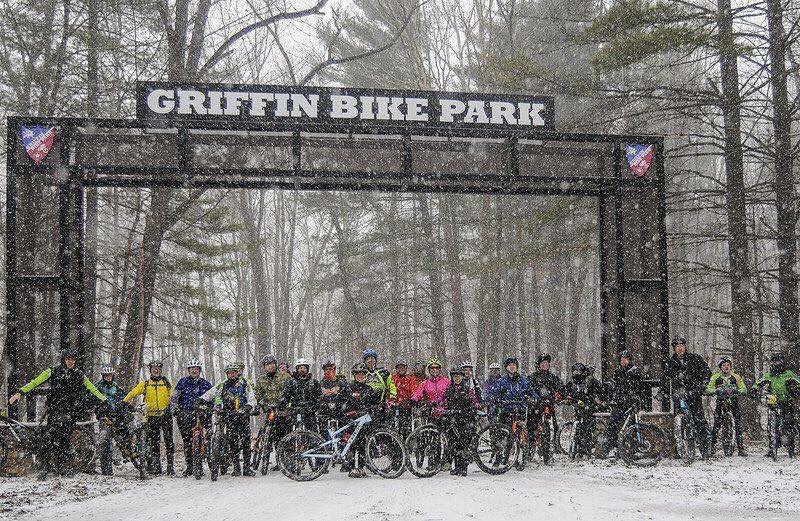 The Griffin Bike Park entrance with riders standing in the snow underneath
