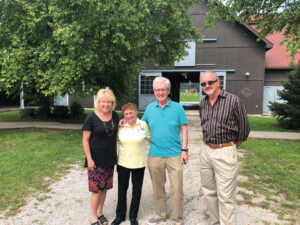 The Harmons stand with President King and Wayne King in the equestrian complex courtyard