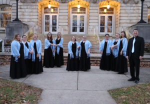 Group photo of the Madrigals on the front porch of the Conservatory of Music.
