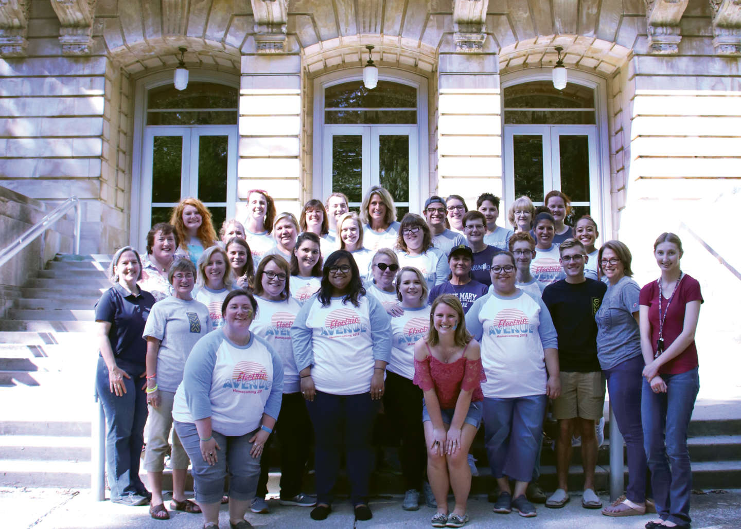 Group of legacy students and their family pose for a group photo on the steps of the conservatory of music.