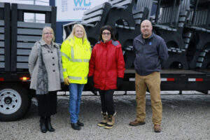 Kinney, Wood, Dolle and Gifford stand in front of delivery truck.