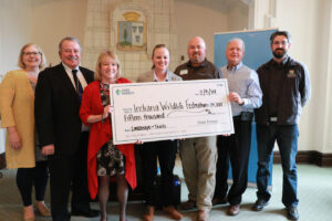 Representatives from SMWC, Duke Energy, and the Indiana Wildlife Federation hold a large check for $15,000 at the ceremony