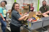 Students sorting food into bins