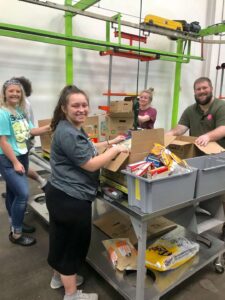 Students sorting food into bins