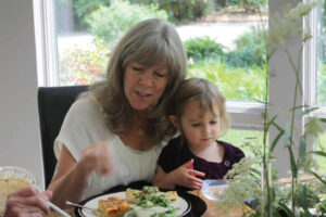 Hollenbeck sitting at a table with her granddaughter