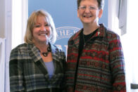 Sister Tomaszewski and President King standing in front of SMWC banner