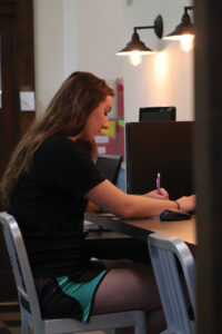 Emma sitting at the computer bar.