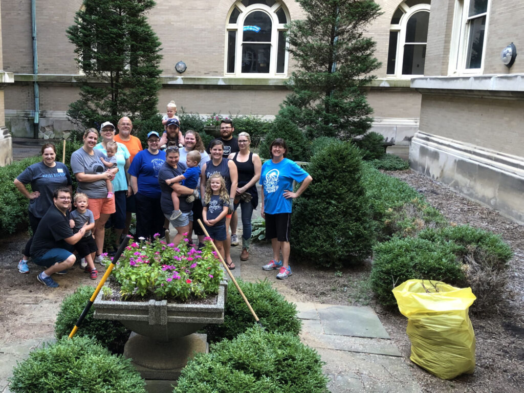 Group of alums standing in the Guerin Courtyard during service project