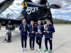 The women's cross country champions with their trophies