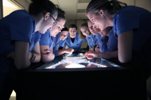 Students looking at table screen at RHIC