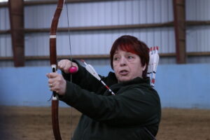 Chris Marks holding up a bow