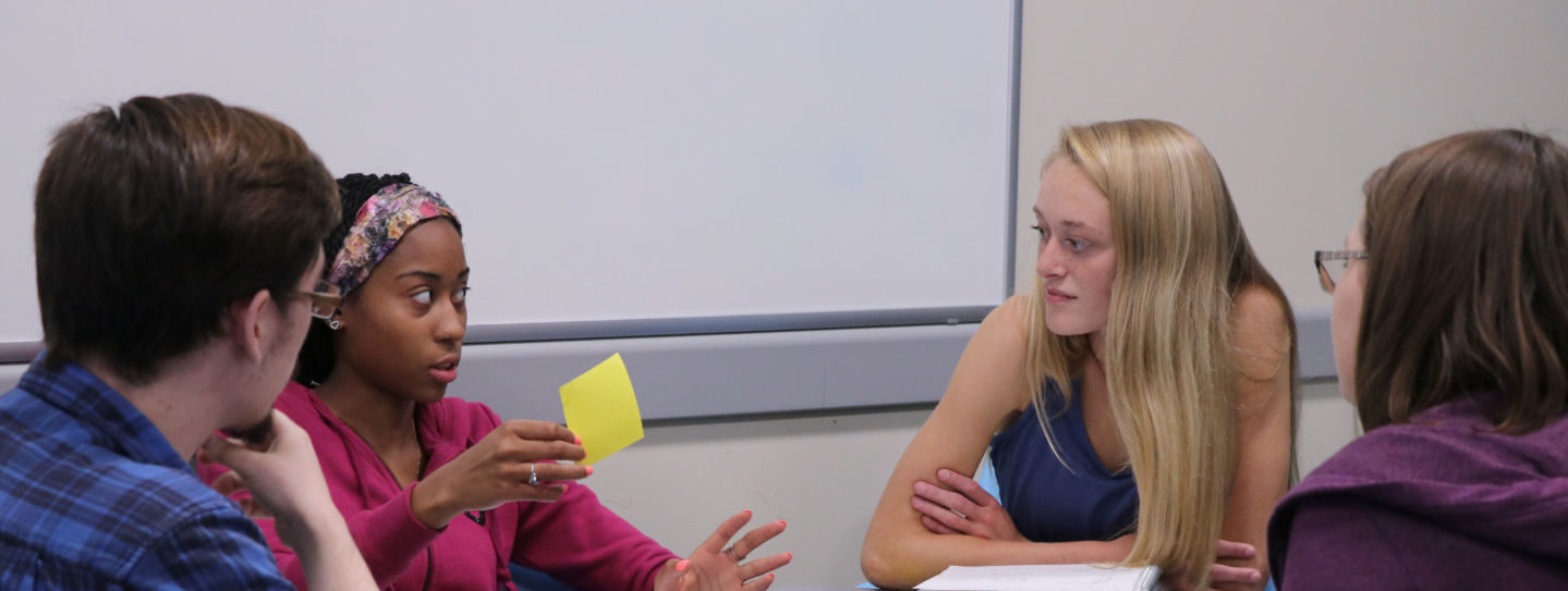 Student holds up sticky note during study session in the LRC