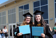 Graduates hold up their diplomas after the 2020 commencement